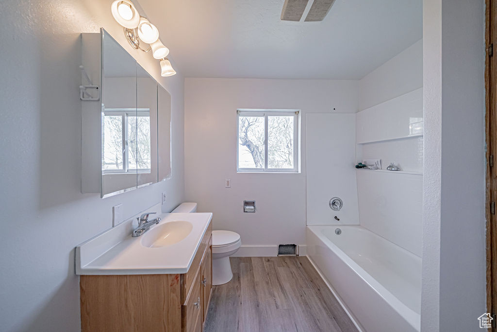 Full bathroom with shower / washtub combination, plenty of natural light, toilet, and oversized vanity