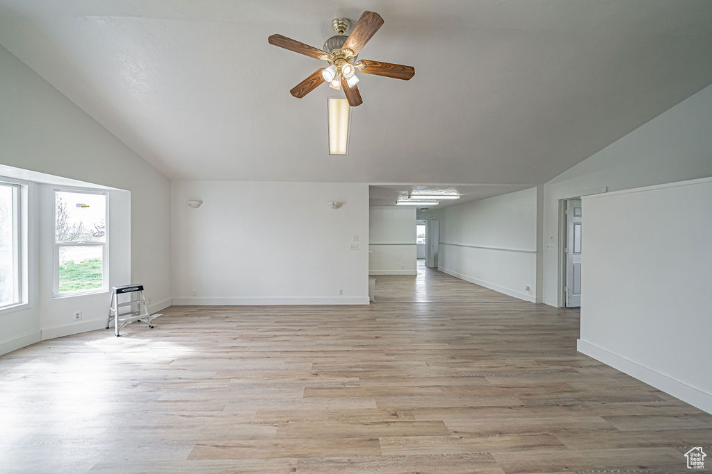 Additional living space with light hardwood / wood-style floors, ceiling fan, and lofted ceiling