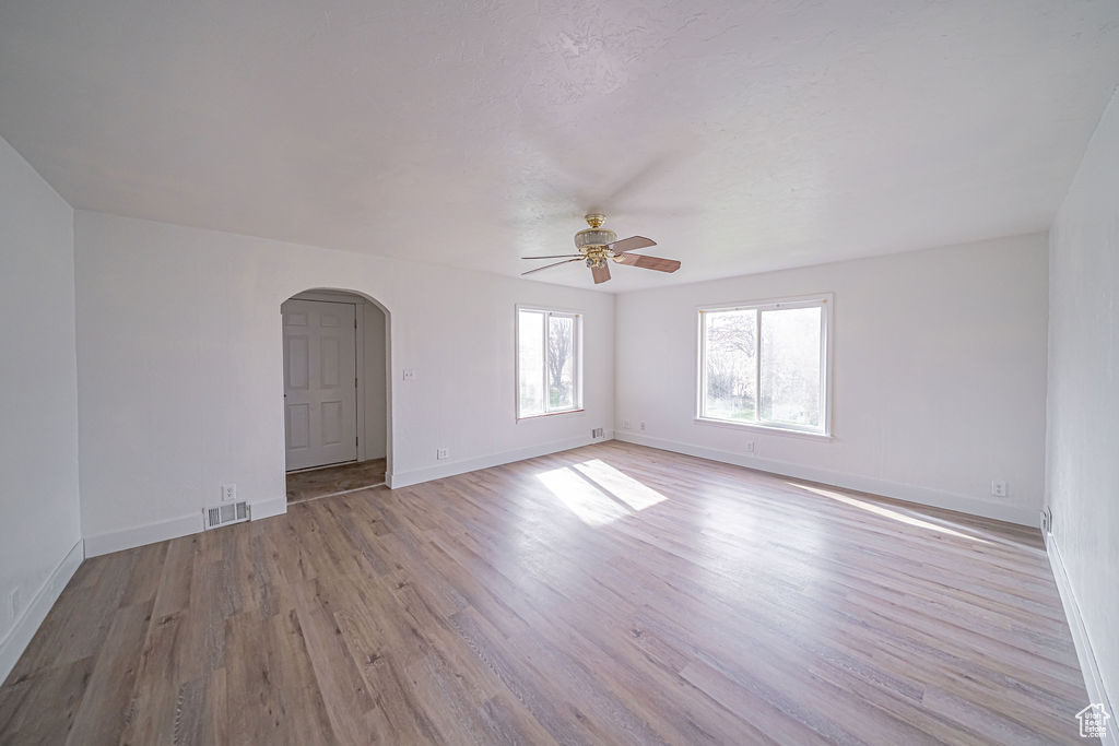 Empty room with hardwood / wood-style floors and ceiling fan