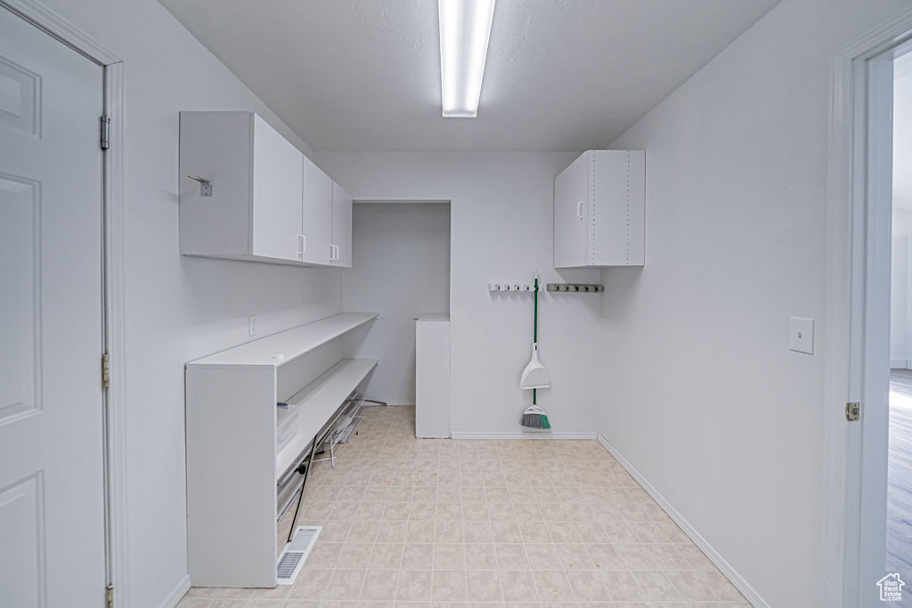 Laundry area featuring light tile flooring