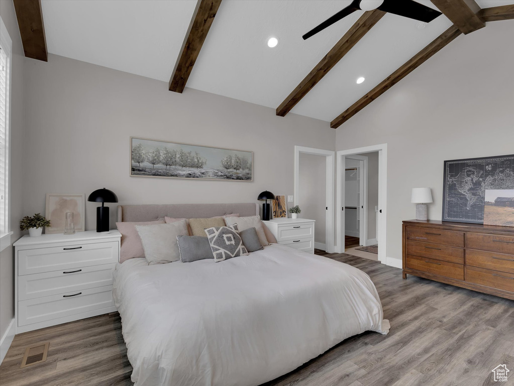 Bedroom featuring beamed ceiling, light hardwood / wood-style floors, ceiling fan, and high vaulted ceiling