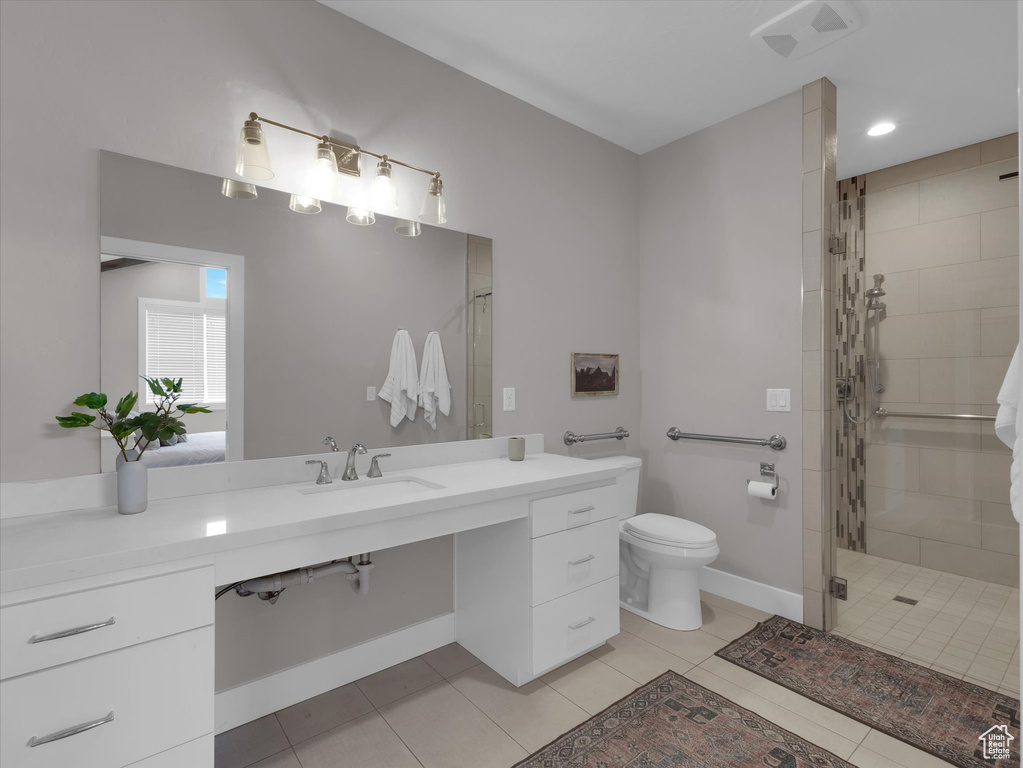 Bathroom featuring toilet, a shower with shower door, tile floors, and vanity
