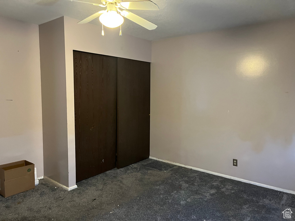 Unfurnished bedroom with a closet, ceiling fan, and carpet flooring