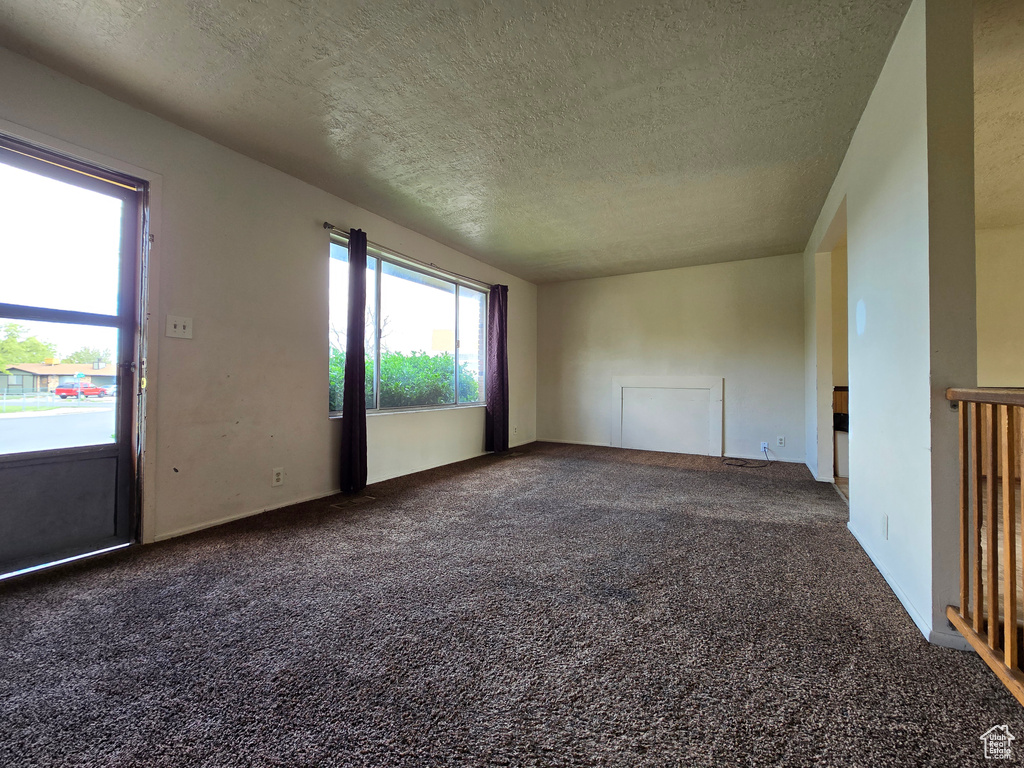 Carpeted spare room with a textured ceiling