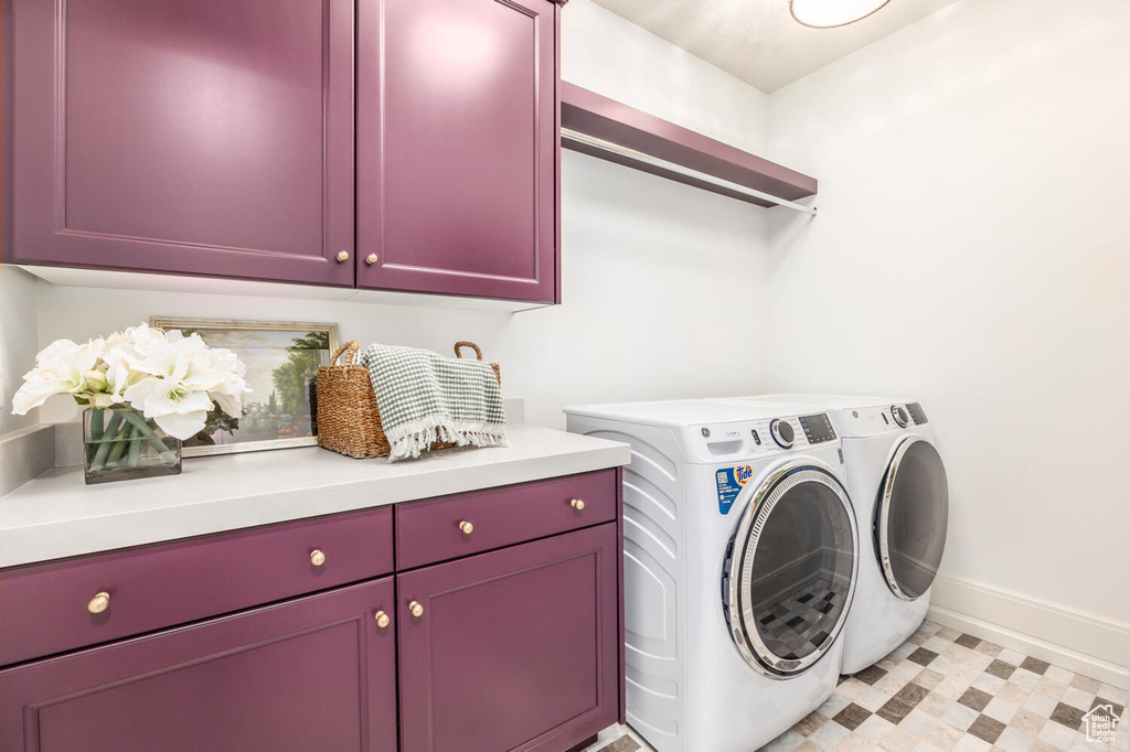 Laundry room with washer and clothes dryer, cabinets, and light tile floors