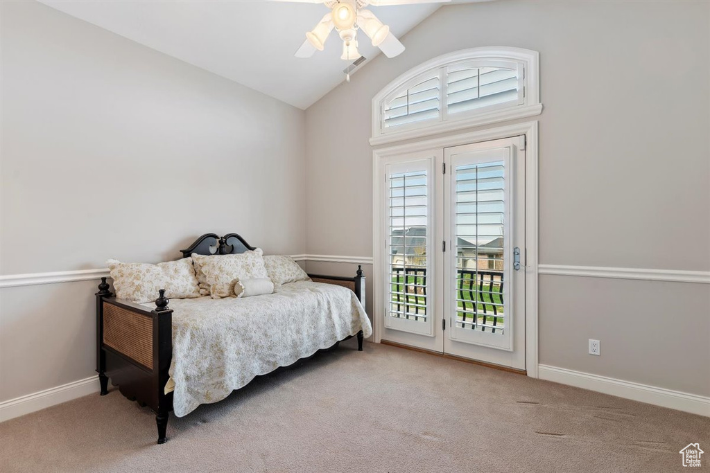 Carpeted bedroom featuring high vaulted ceiling, multiple windows, ceiling fan, and access to exterior
