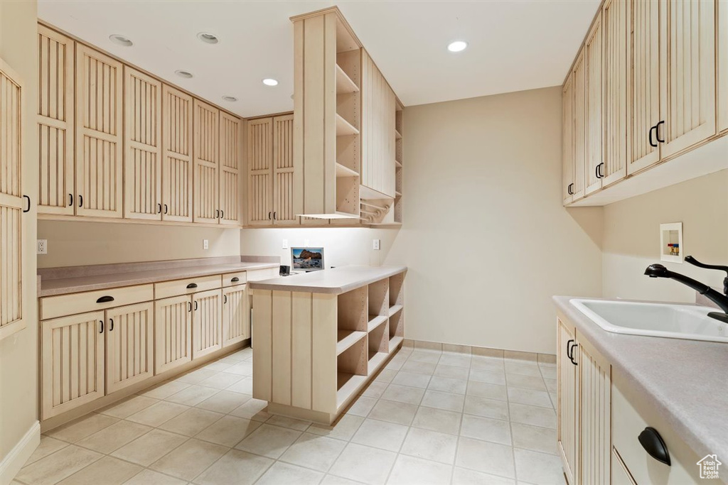 Kitchen with light brown cabinetry, light tile floors, and sink