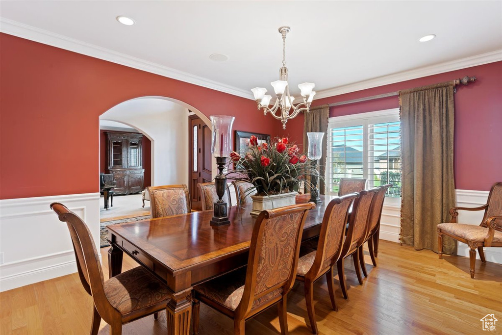 Dining room featuring light hardwood / wood-style flooring, a chandelier, and ornamental molding