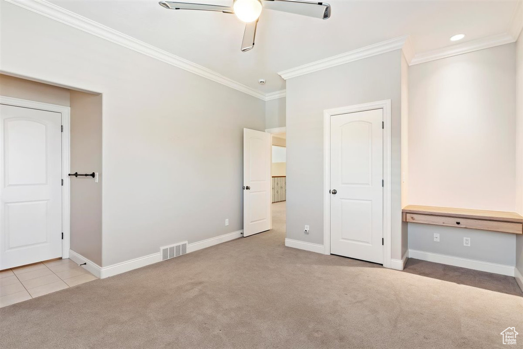 Unfurnished bedroom with crown molding, ceiling fan, and carpet floors
