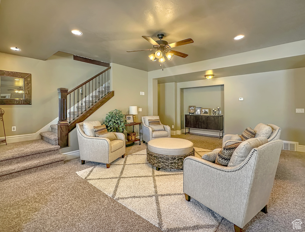 Living room featuring ceiling fan and carpet