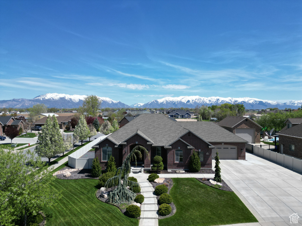 Ranch-style house featuring a front yard, a mountain view, and a garage