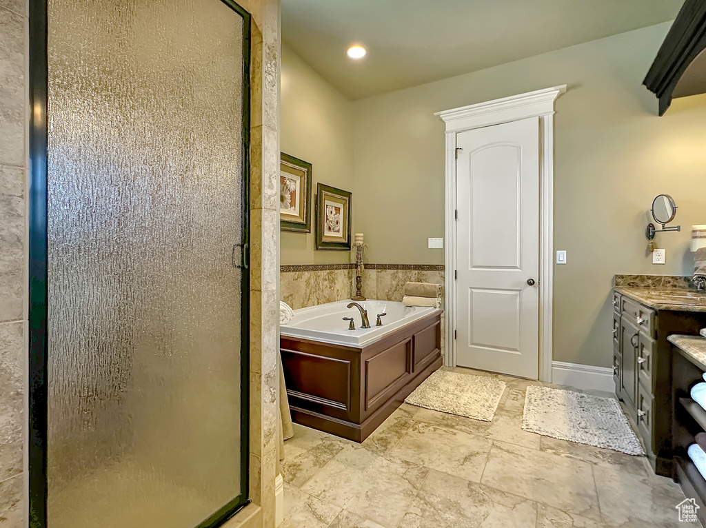 Bathroom featuring vanity, tile floors, and plus walk in shower