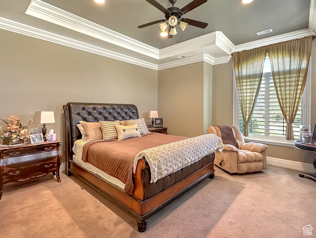 Bedroom featuring a raised ceiling, ceiling fan, crown molding, and carpet flooring
