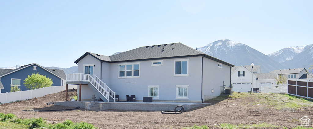 Rear view of house featuring a mountain view and central AC