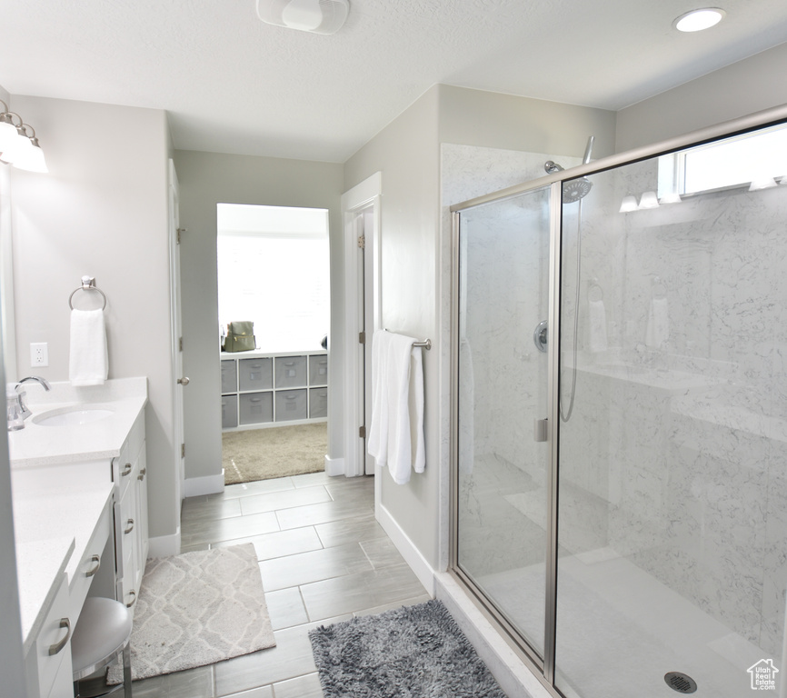 Bathroom featuring a shower with shower door, tile floors, and large vanity