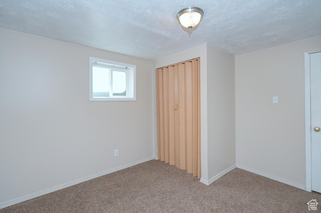 Unfurnished bedroom featuring a textured ceiling and carpet
