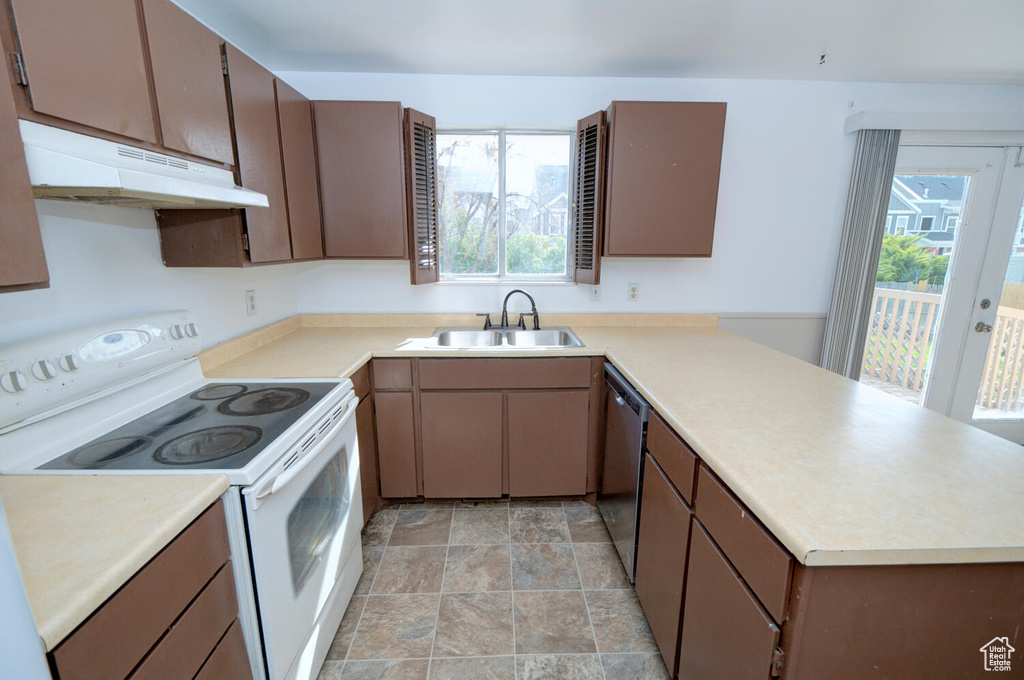Kitchen featuring light tile flooring, a wealth of natural light, sink, and white range with electric cooktop
