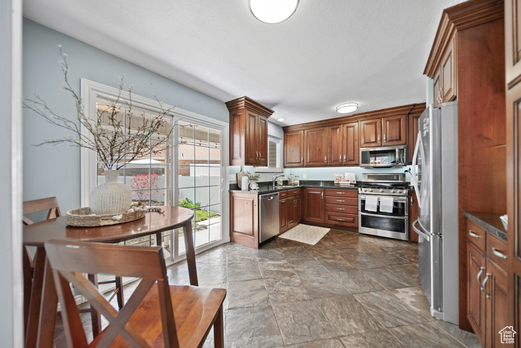 Kitchen featuring tile flooring, sink, and stainless steel appliances