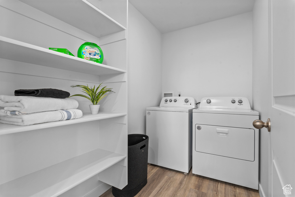 Laundry area with hardwood / wood-style floors, hookup for a washing machine, and washer and dryer
