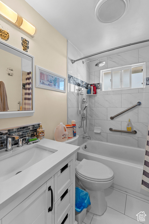 Full bathroom featuring oversized vanity, shower / bathtub combination with curtain, toilet, and tile floors