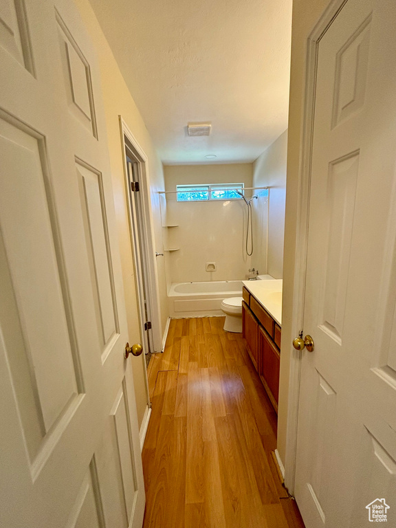 Full bathroom featuring vanity, shower / tub combination, hardwood / wood-style floors, and toilet