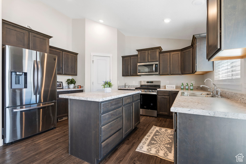 Kitchen featuring dark brown cabinetry, a kitchen island, sink, stainless steel appliances, and dark hardwood / wood-style floors