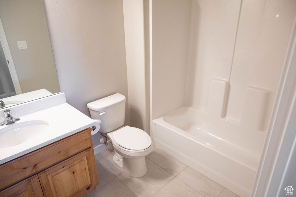 Full bathroom featuring toilet, tile flooring, vanity, and shower / bathtub combination