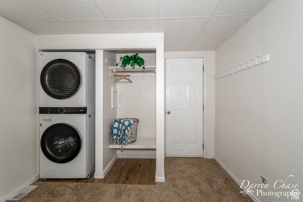 Washroom with carpet flooring and stacked washer and dryer