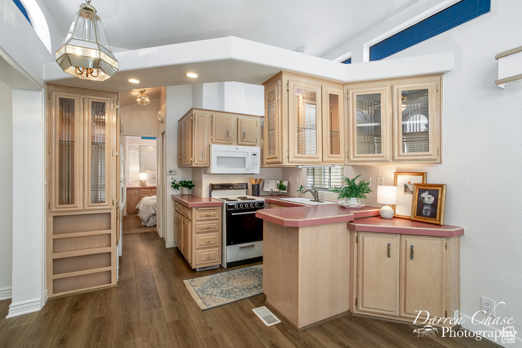 Kitchen featuring light brown cabinets, white appliances, dark wood-type flooring, and sink