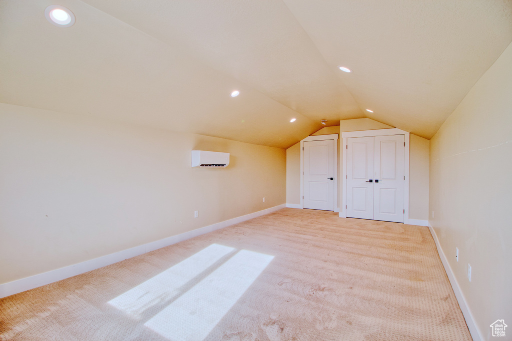 Bonus room featuring vaulted ceiling, carpet floors, and a wall mounted AC