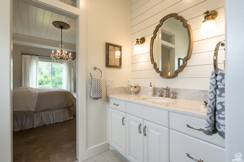 Bathroom with vanity with extensive cabinet space and an inviting chandelier