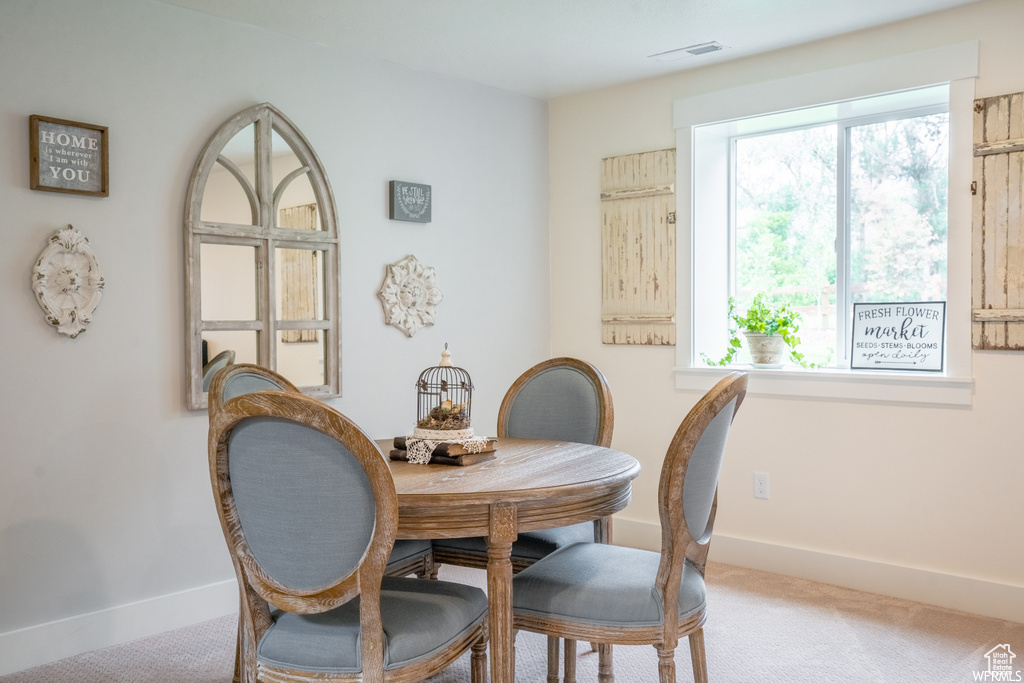 Dining area with plenty of natural light and carpet flooring