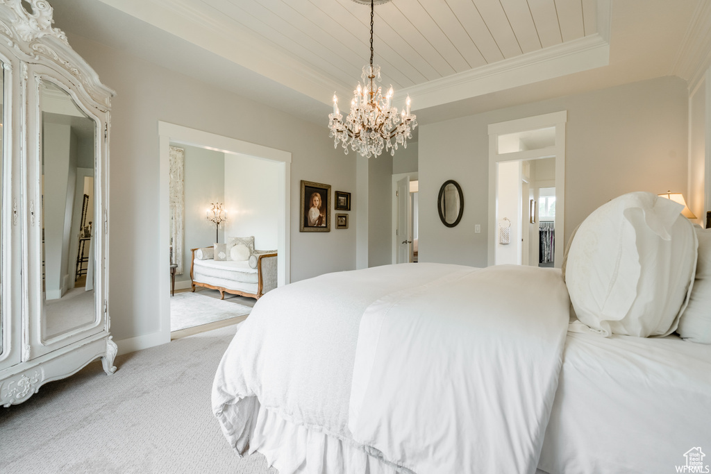 Bedroom with a notable chandelier, carpet flooring, and a tray ceiling