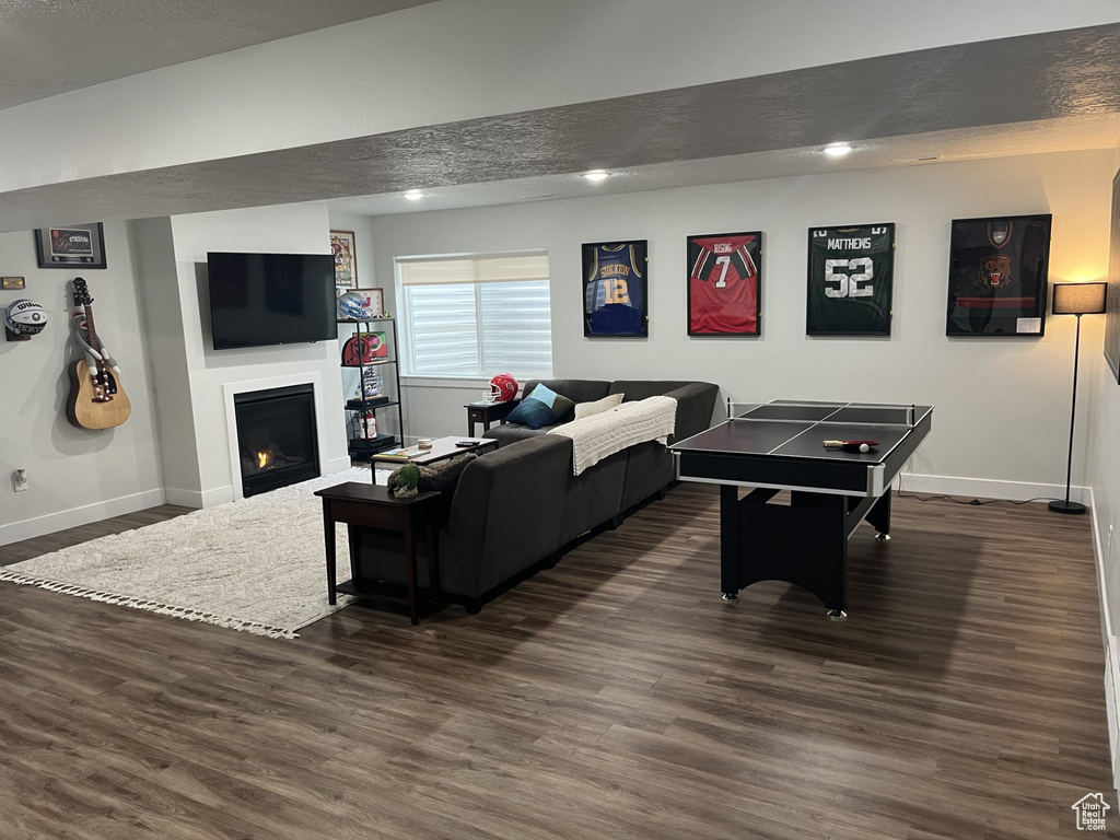 Rec room with dark hardwood / wood-style floors and a textured ceiling