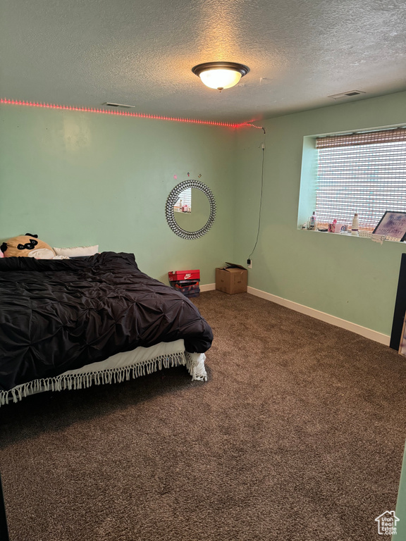 Bedroom featuring carpet flooring and a textured ceiling