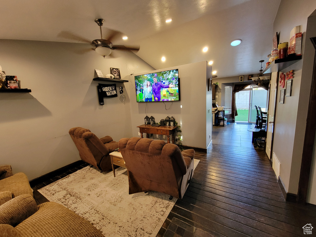 Living room featuring ceiling fan, dark hardwood / wood-style floors, and lofted ceiling