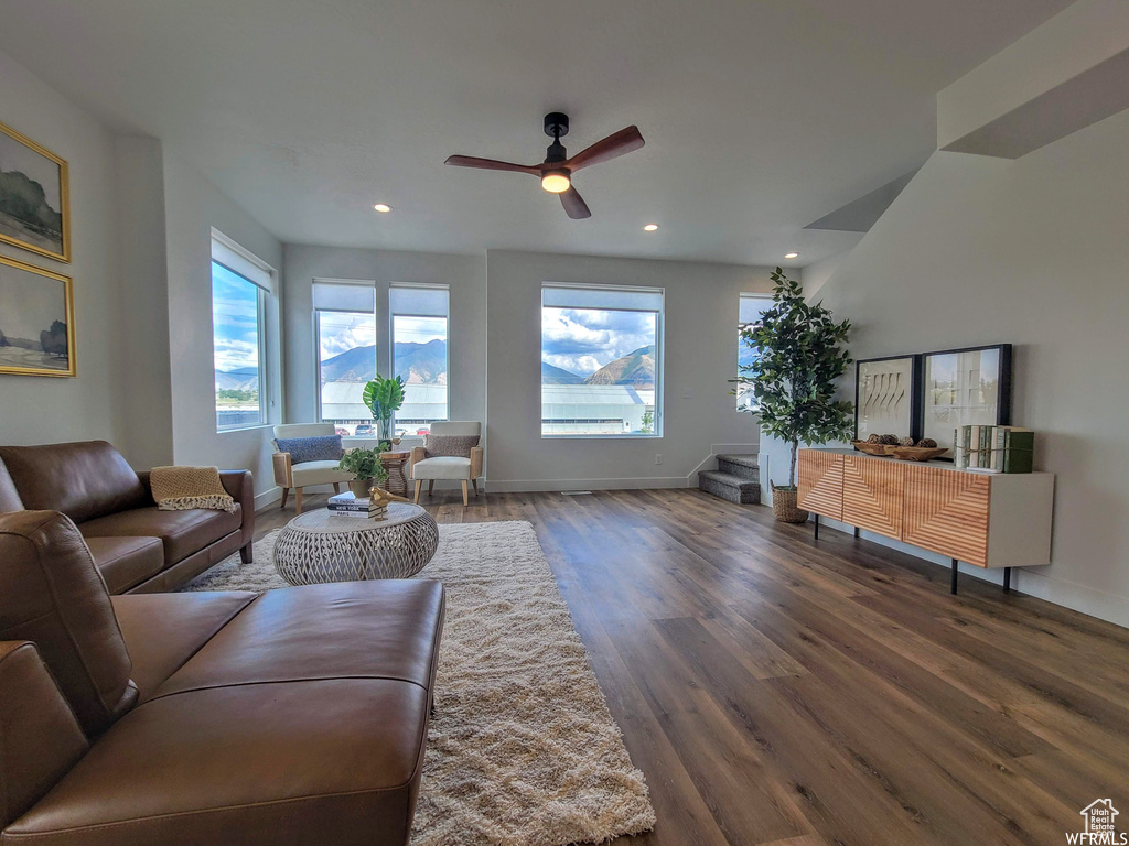 Living room with dark hardwood / wood-style flooring and ceiling fan