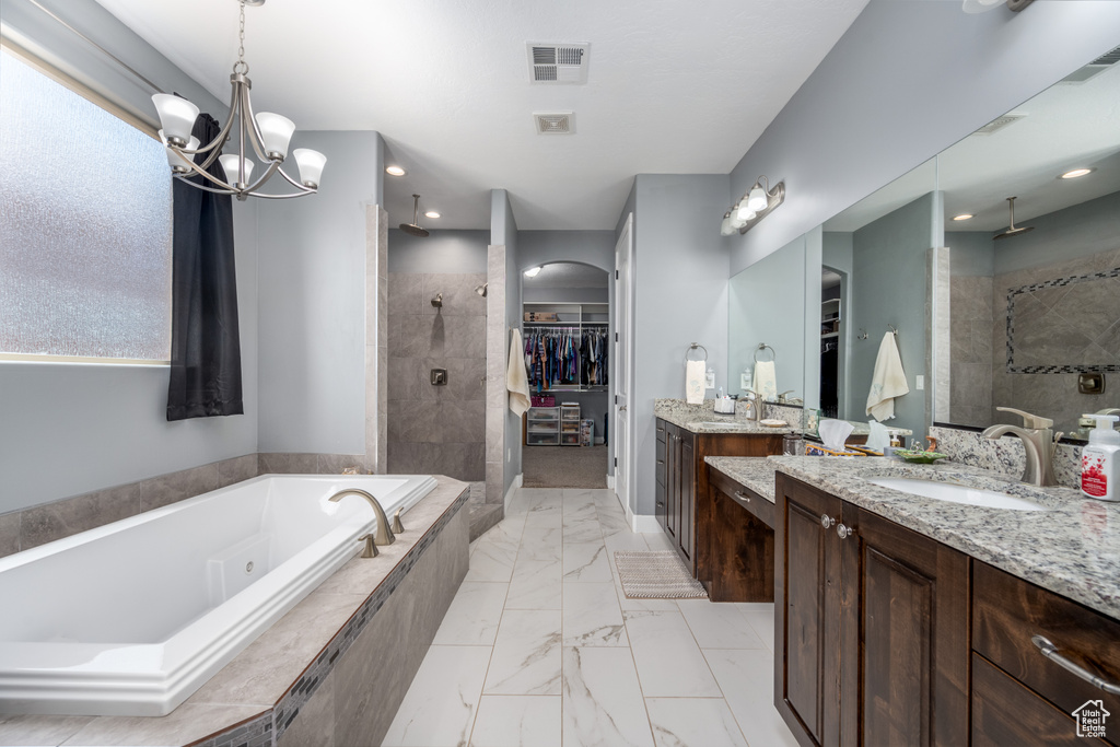 Bathroom with a chandelier, vanity, shower with separate bathtub, and tile flooring