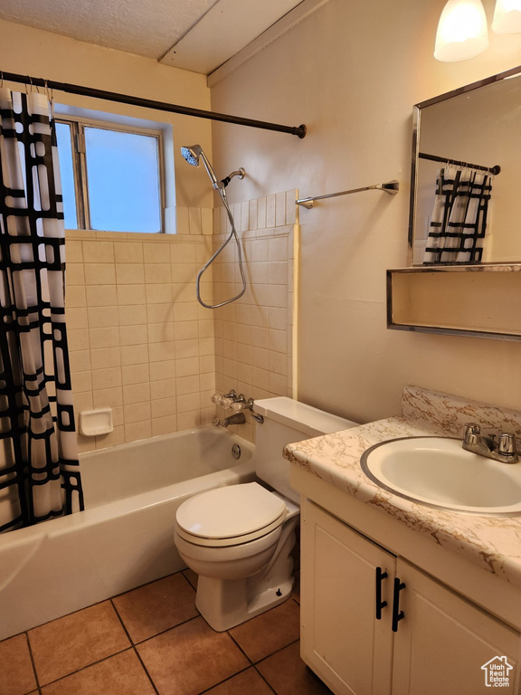 Full bathroom with vanity with extensive cabinet space, shower / tub combo, toilet, and tile floors