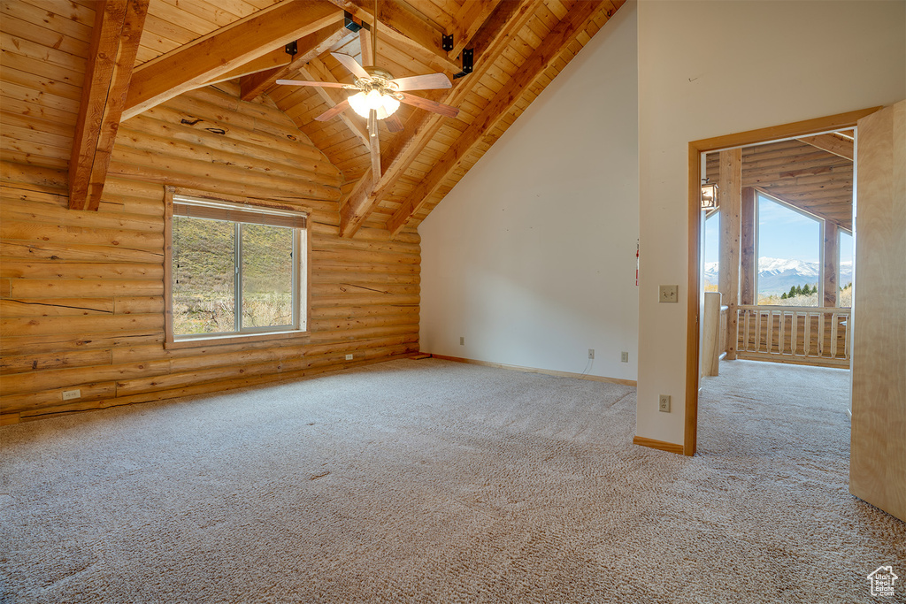 Spare room with wood ceiling, carpet flooring, log walls, and beamed ceiling