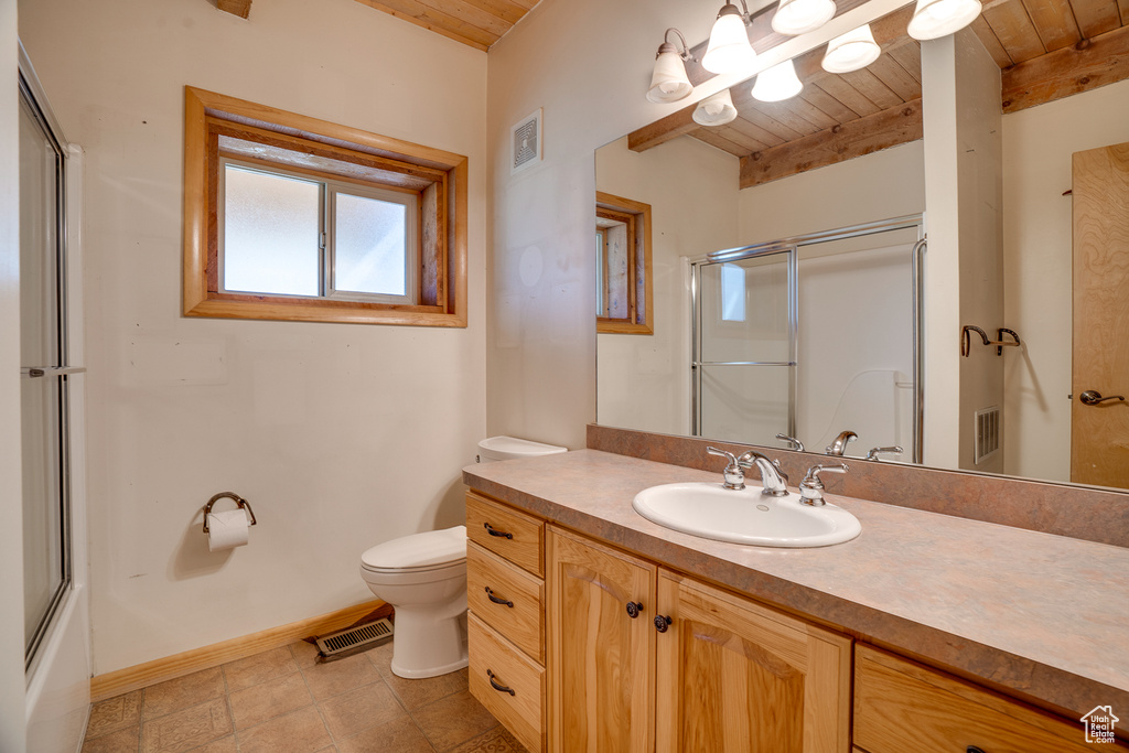 Full bathroom featuring oversized vanity, tile floors, toilet, wooden ceiling, and shower / bath combination with glass door