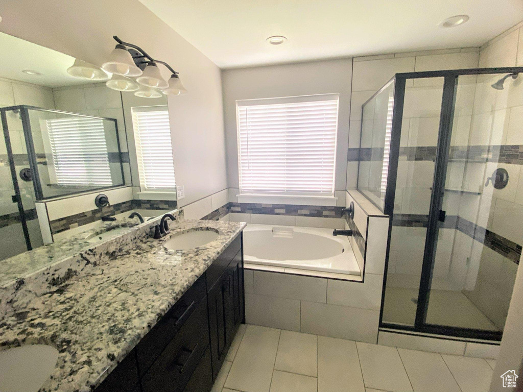 Bathroom with separate shower and tub, tile floors, and double sink vanity