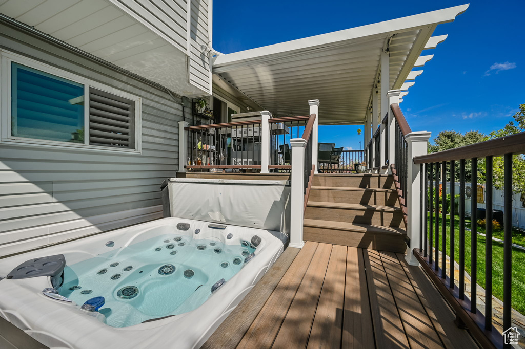 Deck featuring an outdoor hot tub