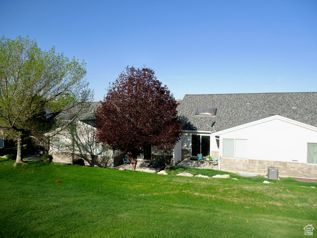 Rear view of property with a yard