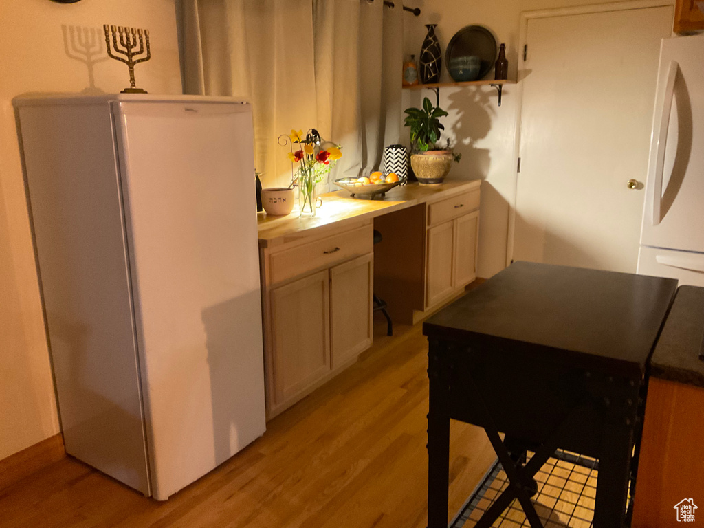 Kitchen with white refrigerator and light hardwood / wood-style floors