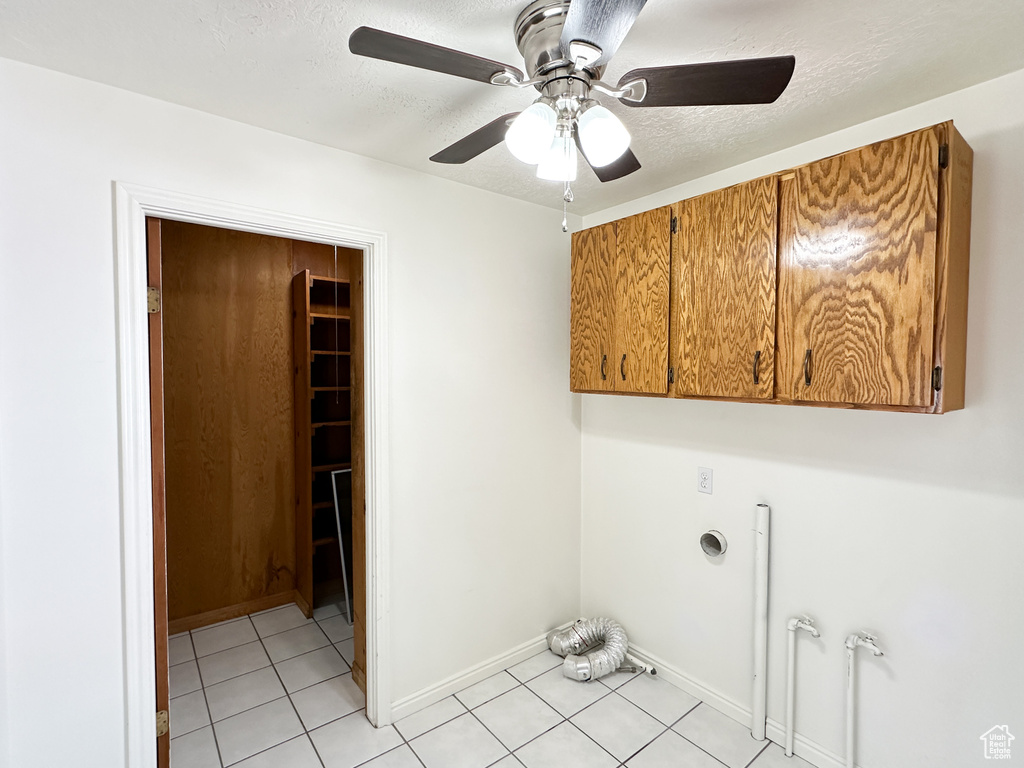 Washroom featuring cabinets, ceiling fan, and light tile floors