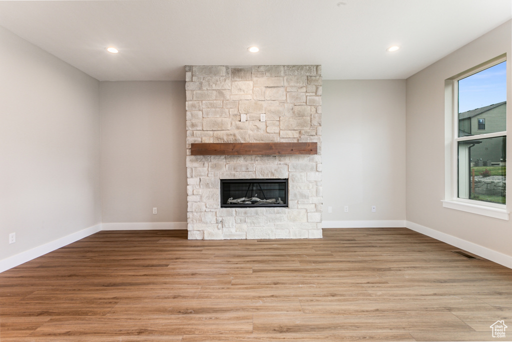 Unfurnished living room featuring light wood-type flooring and a fireplace