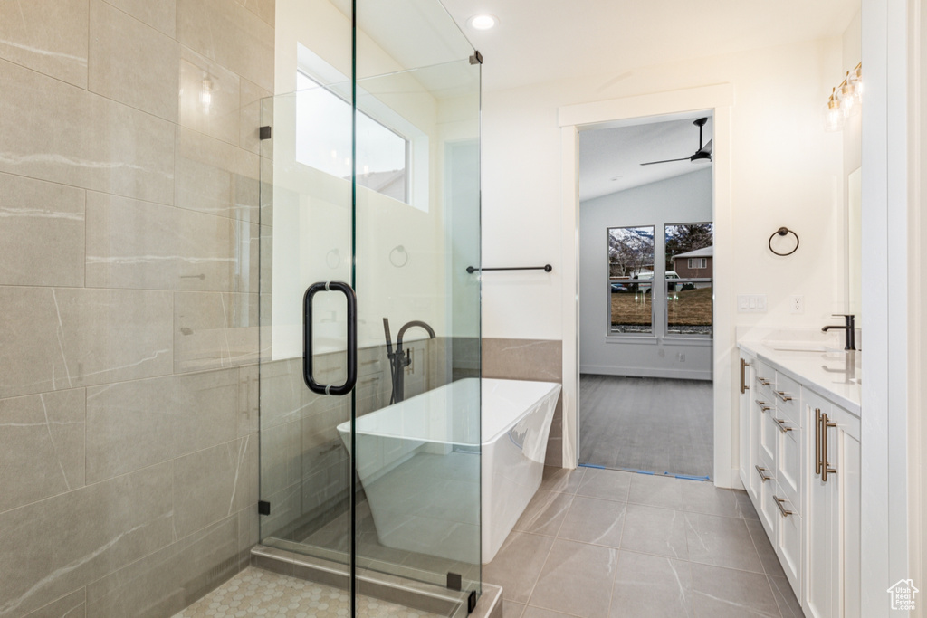Bathroom featuring a shower with door, tile floors, vanity, ceiling fan, and lofted ceiling