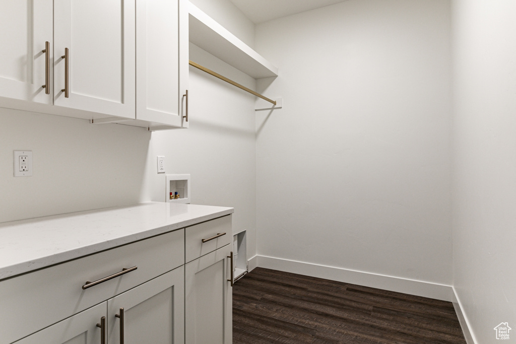 Clothes washing area featuring cabinets, washer hookup, and dark hardwood / wood-style floors