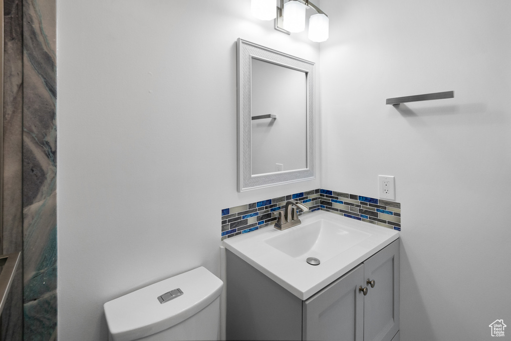 Bathroom featuring tasteful backsplash, vanity, and toilet